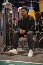 Man sitting on a piece of exercise equipment in a gym
